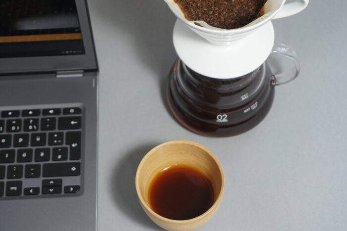 Online-Kaffee-Kurs mit Laptop, Handfilter und Kaffeebecher